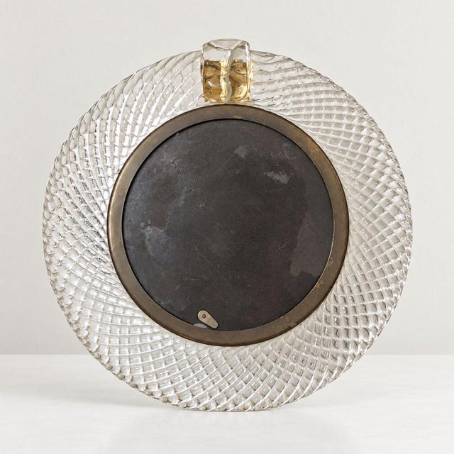 An elegant Italian tabletop photo frame from the 1970s, designed by Tommaso Barbi and crafted from Murano glass and brass....