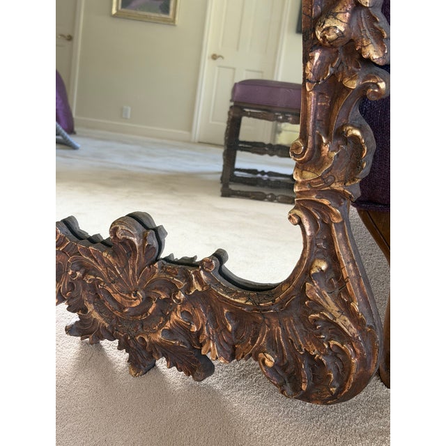 Ornate wall mirror, beautifully carved wood frame with a gold leaf finish. The frame features intricate scrollwork,...