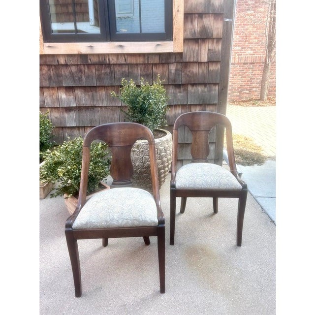 Extraordinary pair of French Empire style mahogany chairs featuring a tub or gondola form frame. Minimally decorated...