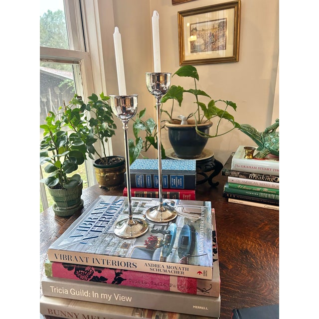 This pair of slender tulip shaped candleholders is silver plate from Italy. They are staggered heights.. the taller is...