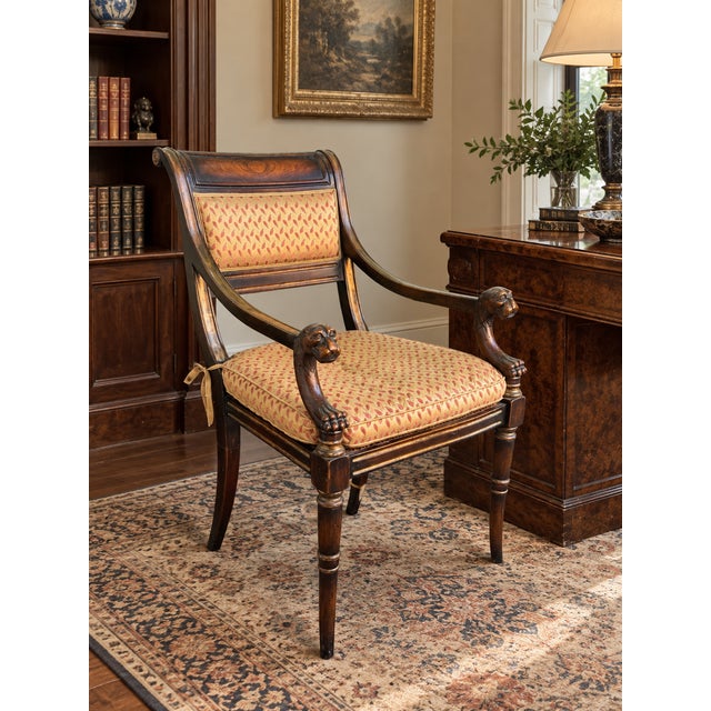 A striking Theodore Alexander armchair inspired by classical Regency and Empire design, featuring a richly finished...