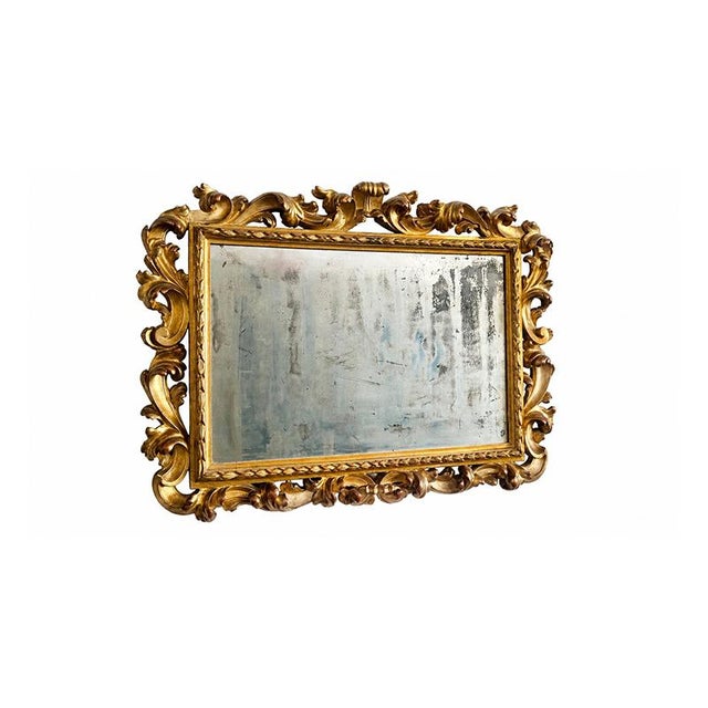 An imposing Baroque-style mirror, embellished with a richly carved and gilded wooden frame. The elegant succession of...