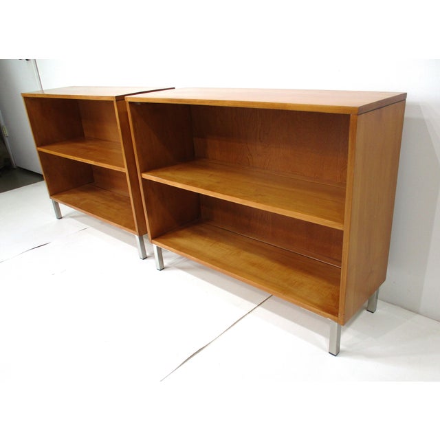 A pair of solid maple wood Mid Century bookcases each with one nonadjustable shelve sitting on squared stainless steel...