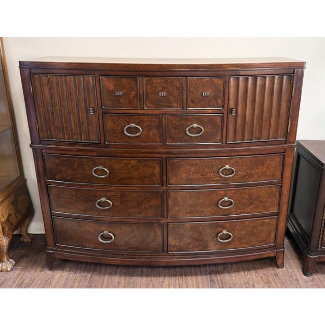This gentleman’s chest combines handsome burled-finish surfaces with a gently curved front, offering a generous mix of...