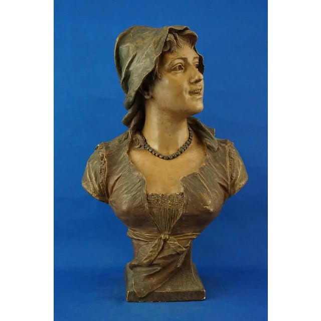A magnificent, large, glazed terracotta bust depicting a peasant woman, crafted by the Austrian Goldscheider factory...