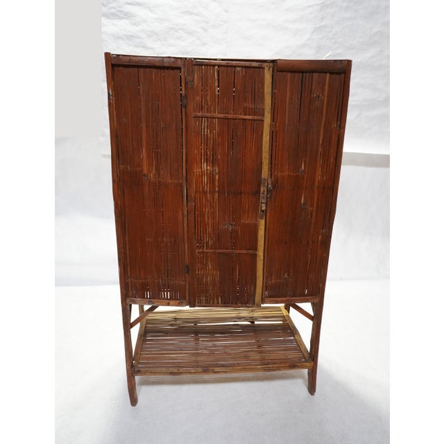 Antique split bamboo cabinet. The face of the cabinet is split into three sections, with the middle section being a narrow...