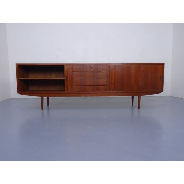 Large teak sideboard with louvre doors from the 1950s. with a shelf on the right and left. Four drawers in the center.