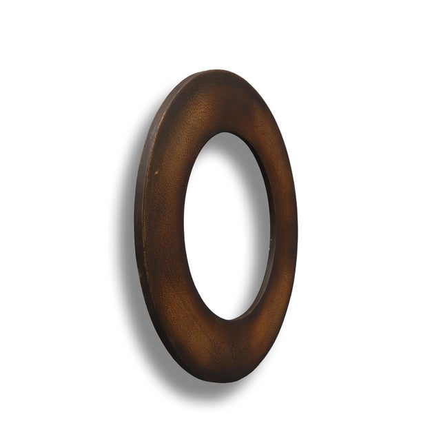This circular wooden mirror frame is finished in a dark paint. Find the similar product in our listing and create a...
