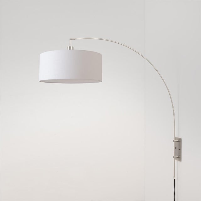 Designed by Peter Morelli in 1960, the Span Wall Mounted Arc Lamp is a modern statement piece featuring a satin nickel...