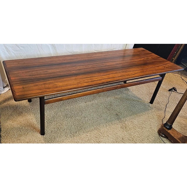 This Mid-Century Danish Rosewood Coffee Table is a timeless piece with an expansive surface of beautiful swirling patterns...