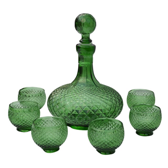 Stunning midcentury textured green glass decanter and matching glasses with ornate base, structure and intricate details....