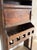 A French kitchen vaisselier in dark carved chestnut, gone nearly black at the edges from old wax. An open plate rack with...