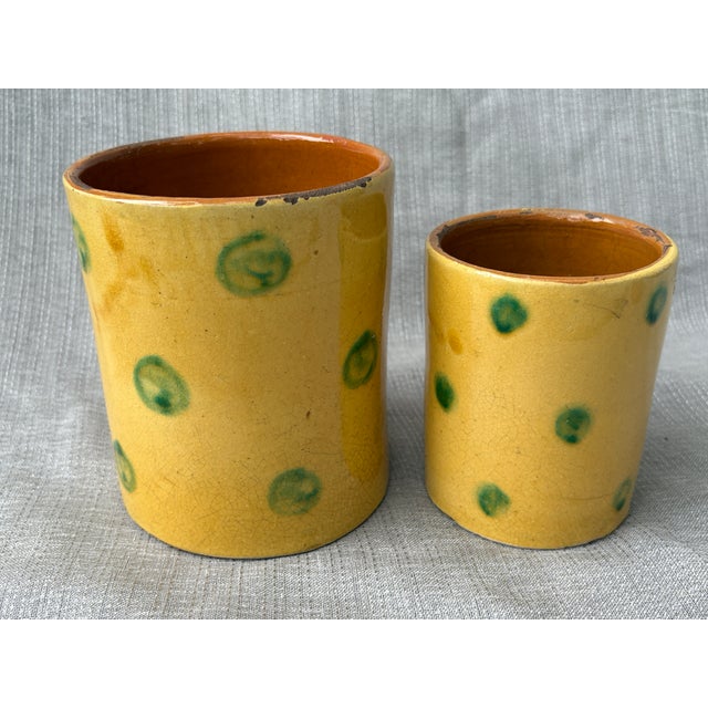 Charming vintage set of 2 hand thrown, small nesting terra cotta planters. Each with a rustic yellow glaze finish accented...
