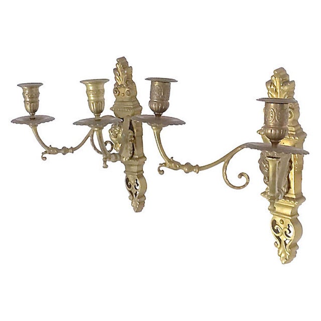 Pair of antique brass cherub and acanthus leaf candle sconces in the Louis XVI style with leaf flourishes on the base and...