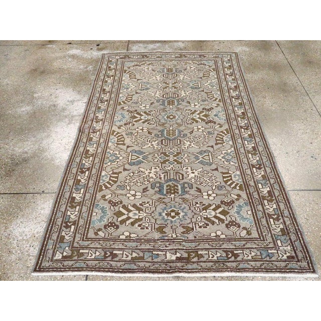This mid-20th-century Persian Malayer rug presents a finely detailed floral composition across a muted grey-brown field....