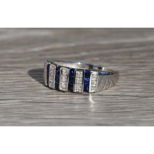 The Enotera Ladies 14K White Gold Sapphire and Diamond Band. Crafted in 14 karat white gold, this wide ladies band...