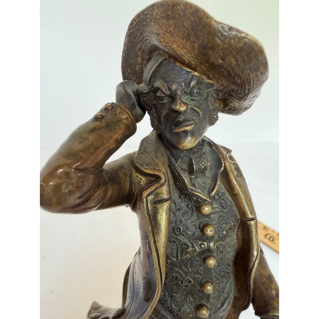 A finely detailed cold-painted bronze figure depicting a gentleman in period dress — tricorn hat, ruffled cravat, richly...