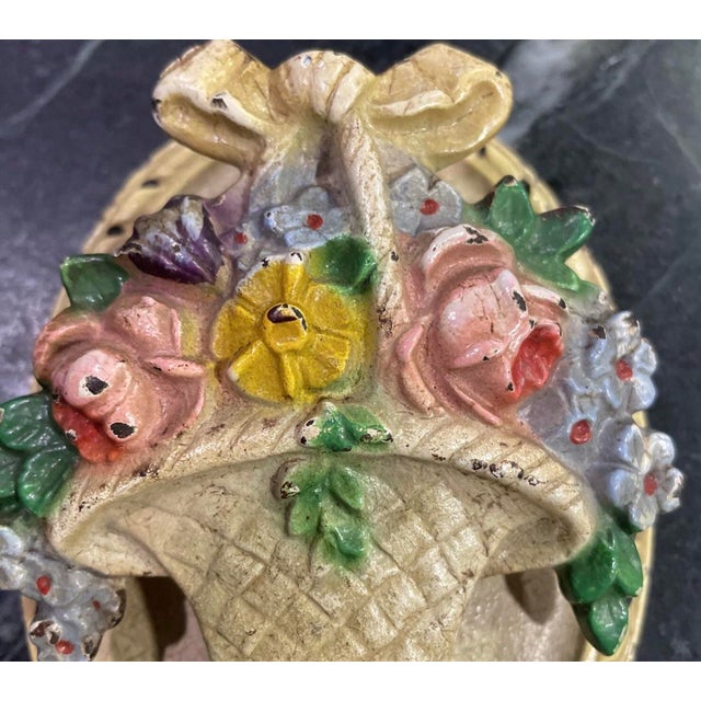 Charming early-20th-century cast iron door knocker in the form of a hand-painted floral basket. Rich with authentic patina...