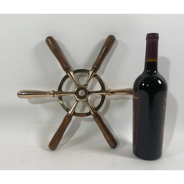 Antique ships wheel with six spokes. Unusual and nicely shaped wheel with six handles, two brass and four wood. The back...
