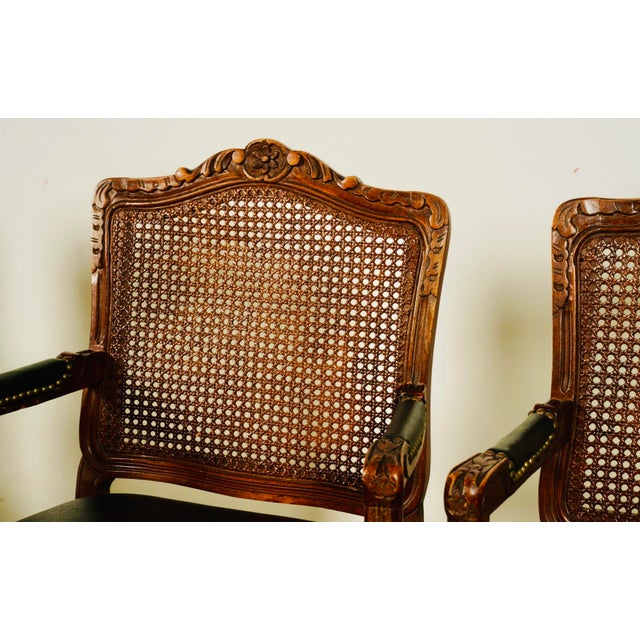 Pair of Carved Cane-Back Armchairs With Leather Seats Bring timeless European charm into your space with this pair of...