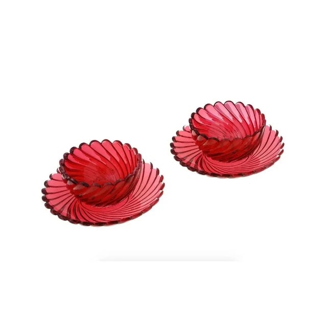A lot of vintage ruby red crystal tableware. A total of two bowls and two plates. The pieces have a swirl design with...