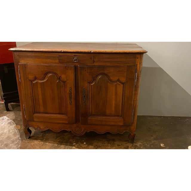 A sturdy French 18th century buffet crafted from walnut with two doors offering ample storage below a single drawer....