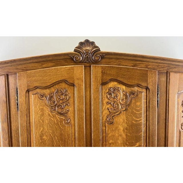 This refined Vintage French Louis style wardrobe presents elegant carved panel doors, a gently shaped cornice with central...