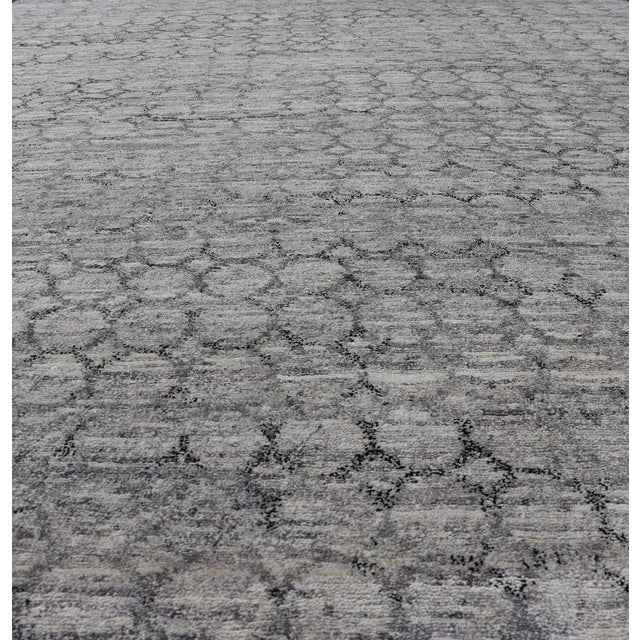 Measures 6'7 x 9'10 The field is rendered in a rich, mature light gray, with blends of neutrals creating a nice balance...