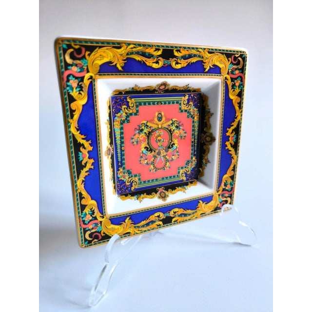 Stunning Versace square plate in Rosenthal porcelain, "Le Rei Soleil". With the iconic drawing of the Sun King, in shades...