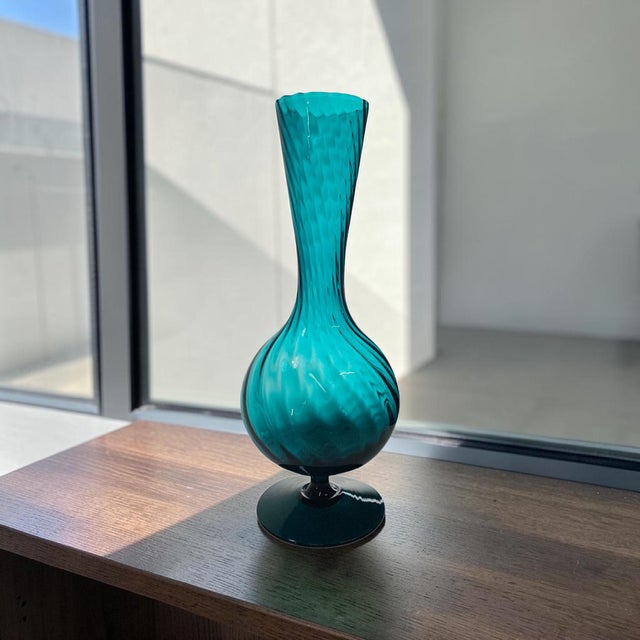 Standing 13 inches tall, this beautiful piece features a rich teal blue color accented by a mesmerizing optic swirl...