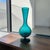 Standing 13 inches tall, this beautiful piece features a rich teal blue color accented by a mesmerizing optic swirl...