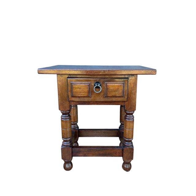 This Spanish side table dates from the 20th century and is crafted in solid wood. The piece features a rectangular top...