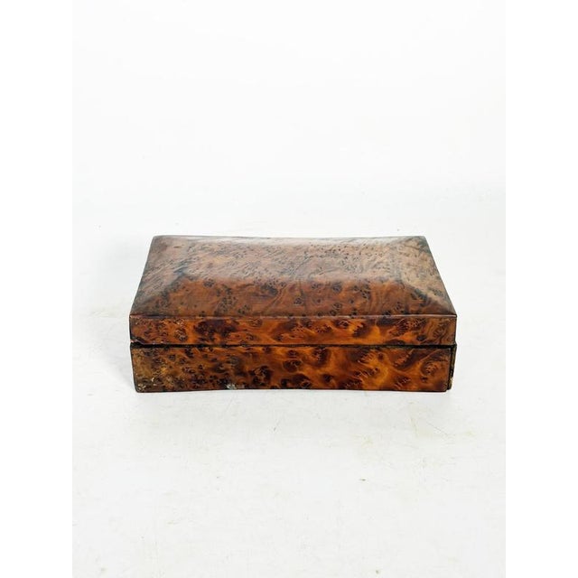 Rectangular wooden box, France, 1970s, characterized by a richly veined veneer, likely burl, offering a particularly...