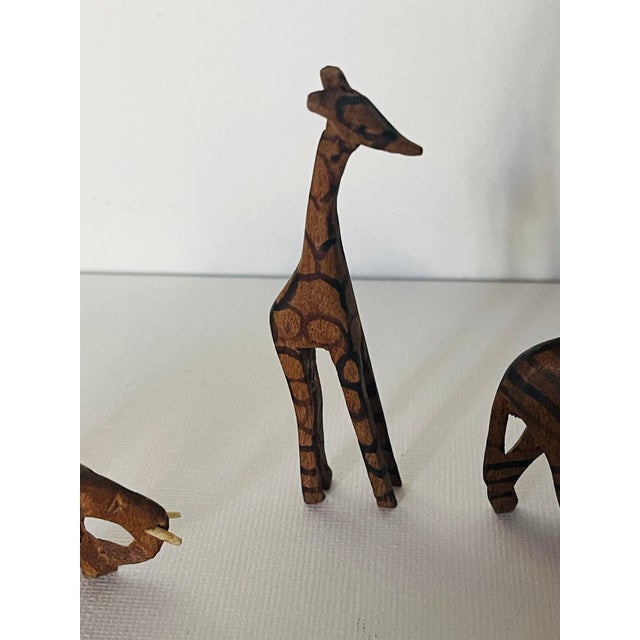 3 S Safari handcarved painted wooden figurines of a giraffe, a zebra and an elephant.