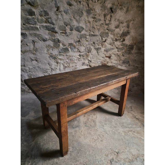 Antique oak dining table from France, dating from approximately 1750–1850. The table has a beautifully aged top made from...