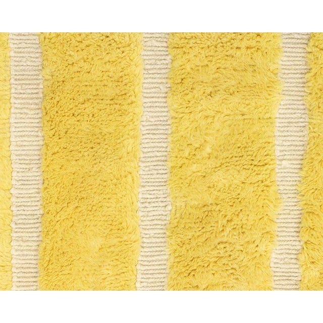 Vibrant hand-knotted wool rug with a Luminous Yellow base, featuring handwoven slender Ivory vertical stripes, infusing...