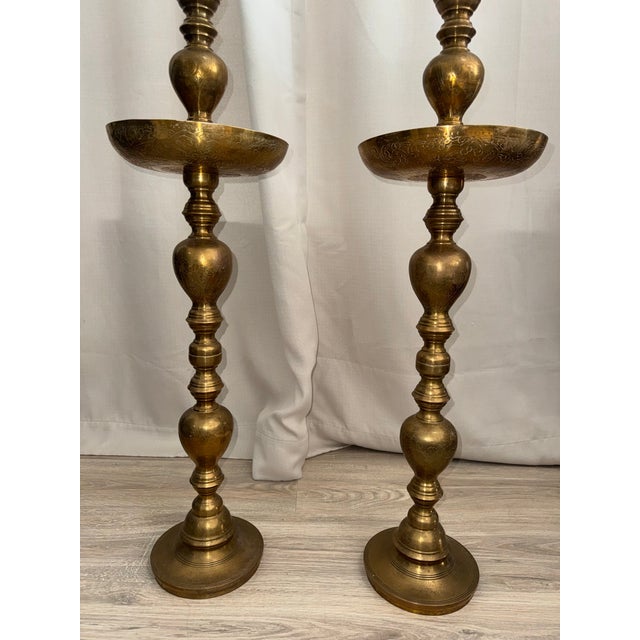 Elevate your space with this spectacular pair of monumental 39-inch vintage Moroccan solid brass floor candlesticks. These...