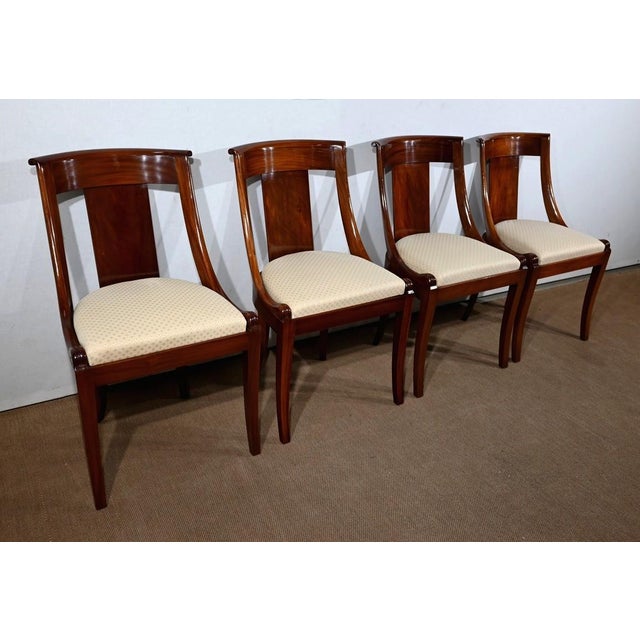 Set of four solid mahogany chairs, with openwork backs, composed of a central element joining a concave crosspiece. The...