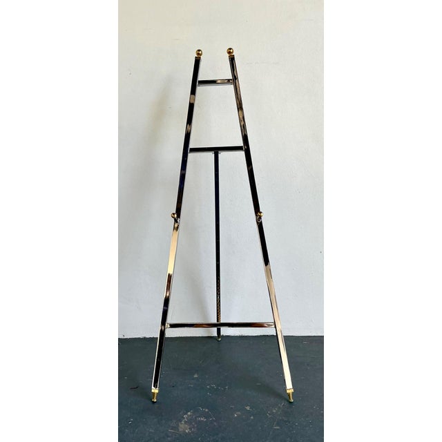 This elegant vintage chrome and brass easel exemplifies the refined modernist design sensibility of the mid-20th century....