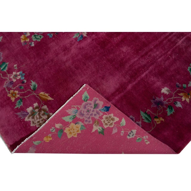 Beautiful antique Chinese Art Deco hand-knotted wool rug with a red field. This Chinese rug has multi-color accents in a...