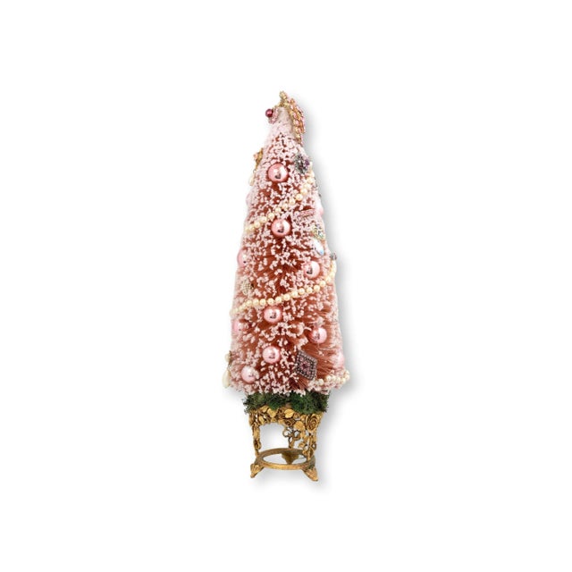This holiday tree is pure midcentury Barbie fantasy, frosted in blush bottle brush and dripping with pearls, rhinestones,...