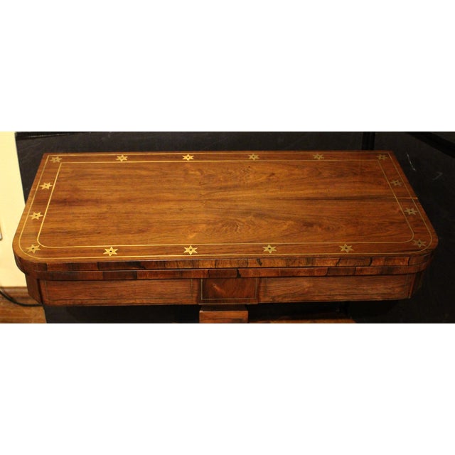 English Regency period swivel top games table, circa 1815. Rosewood with extensive brass inlays of stars & lines on nearly...