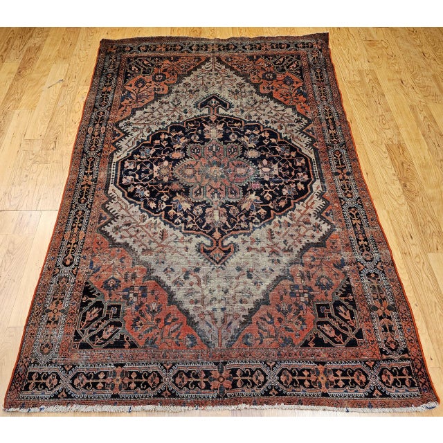 "This early 20th-century Farahan Sarouk area rug features a majestic medallion floral design in a rich palette of navy...