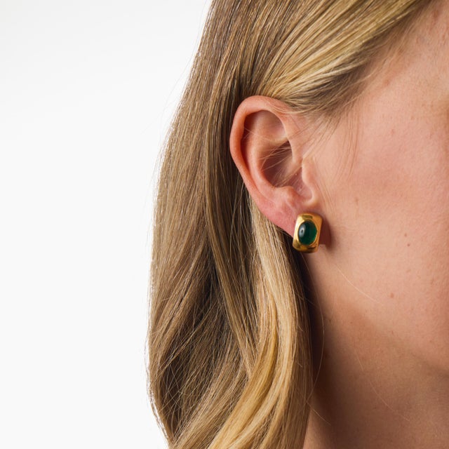 These striking vintage hoop earrings showcase two beautifully polished cabochon cut emeralds totaling approximately 4.70...