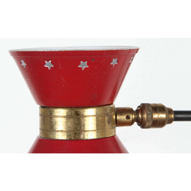 Articulated sconce in the style of Stilnovo. Red enamel shade has star cut-out detail on either side.