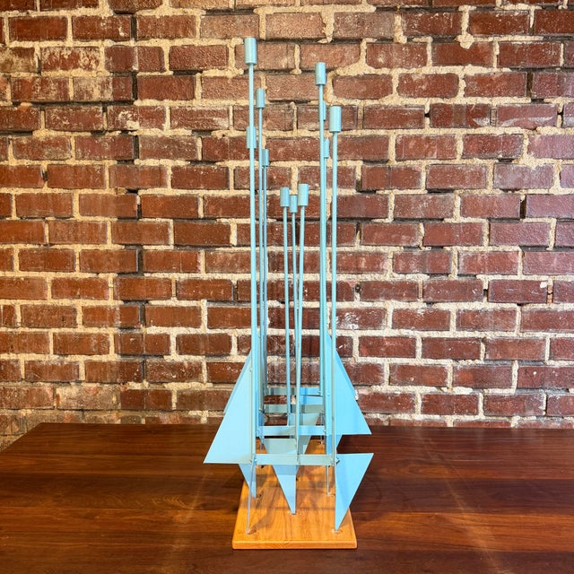 This is a rare Don Drumm candelabra sculpture. It features 11 tall candlestick holders with multiple steel plate triangles...