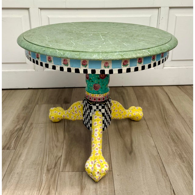 Here is a charming vintage hand-painted accent table in the style of Mackenzie-Childs, featuring colorful floral...
