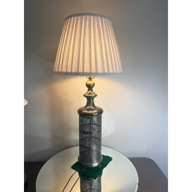 pair of MCM pierced metal lamps inspired by Moroccan spice jars, featuring a cylindrical pierced metal base with a...