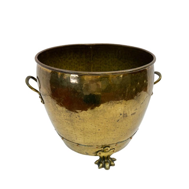 This 19th-century European hammered brass jardinière is a striking example of traditional artisanal metalwork. The vessel...