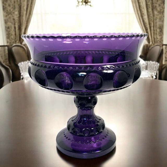 This antique pressed glass compote dates to the early 20th century and displays a bold thumbprint band design with a...